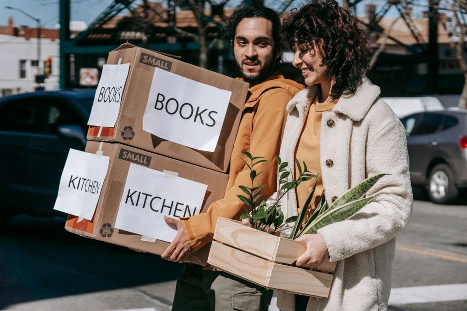 Family carrying moving boxes into their new residential home